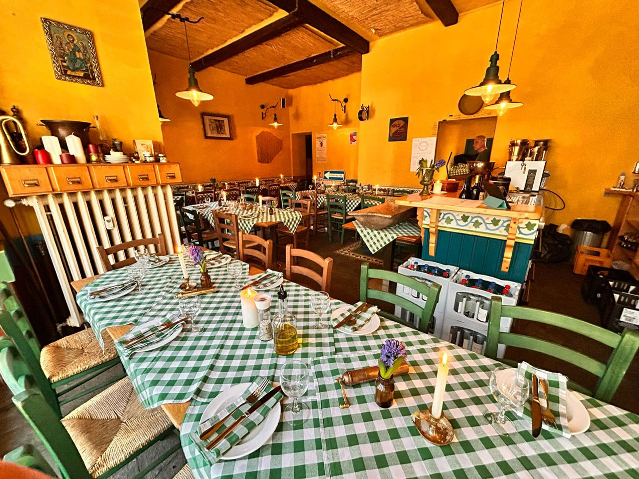 Gemütliches Restaurant mit karierten Tischdecken, Holzstühlen und rustikalem Dekor in warmen Farben.